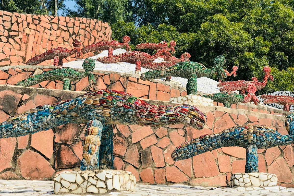 Nek Chand's mosaic sculptures of figures and animals arranged on terraced stone walls at the Rock Garden